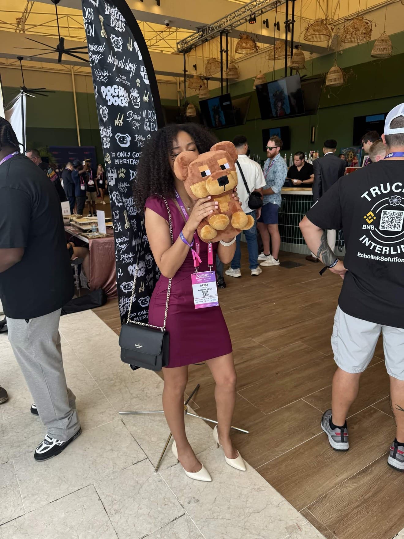 ArtsyMeta (@ArtsyMeta) at a Doginal Dogs booth holding a plush dog